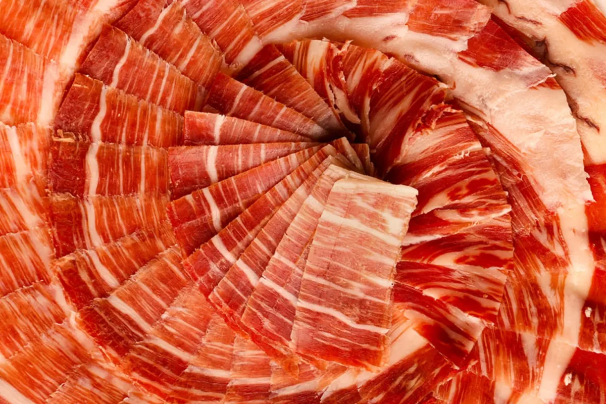 Jamón español cortado en plato blanco con presentación profesional